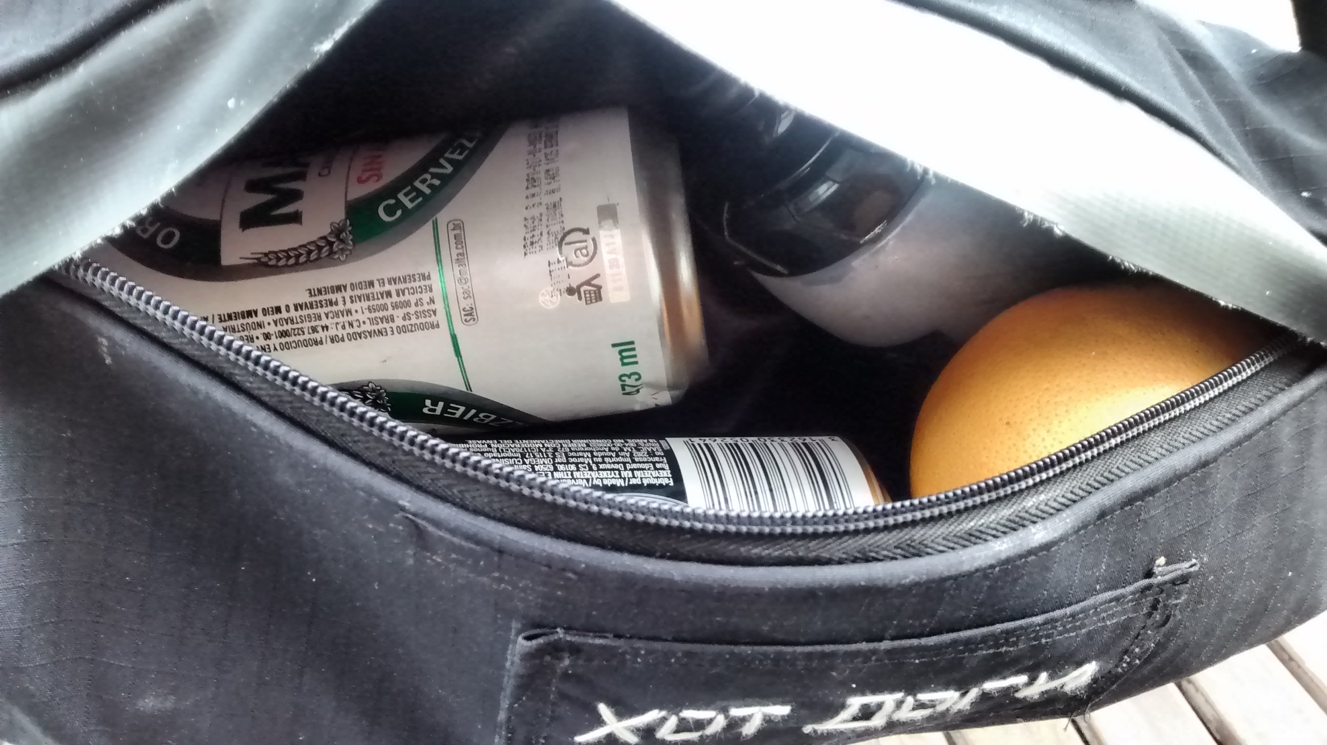 sneak peek a los contenidos del bolso con dos birras, un pomelo y una botella