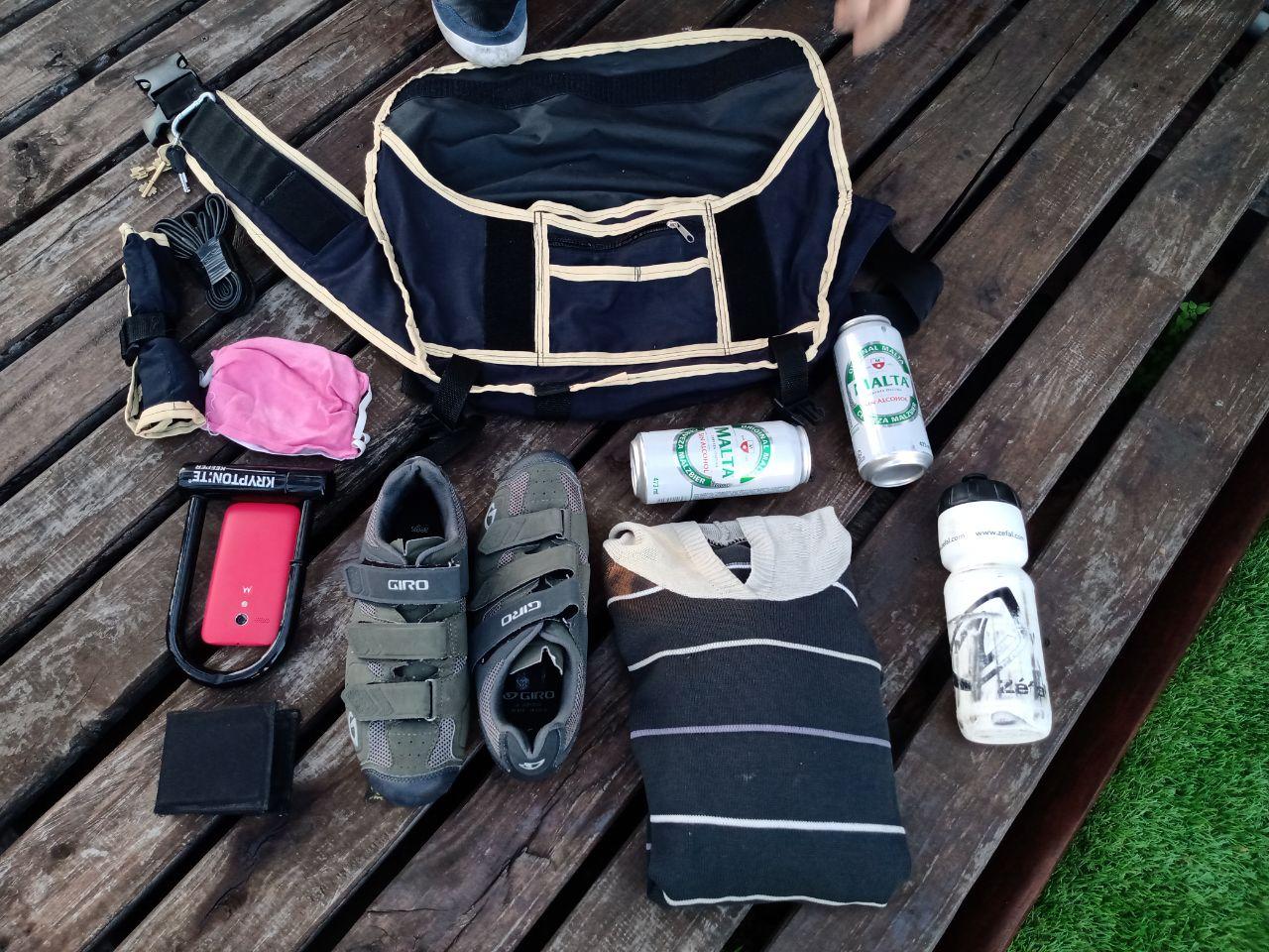 el bolso junto a todos sus contenidos: un par de birras, un par de zapatillas, un candado, herramientas, una botella y un buzo