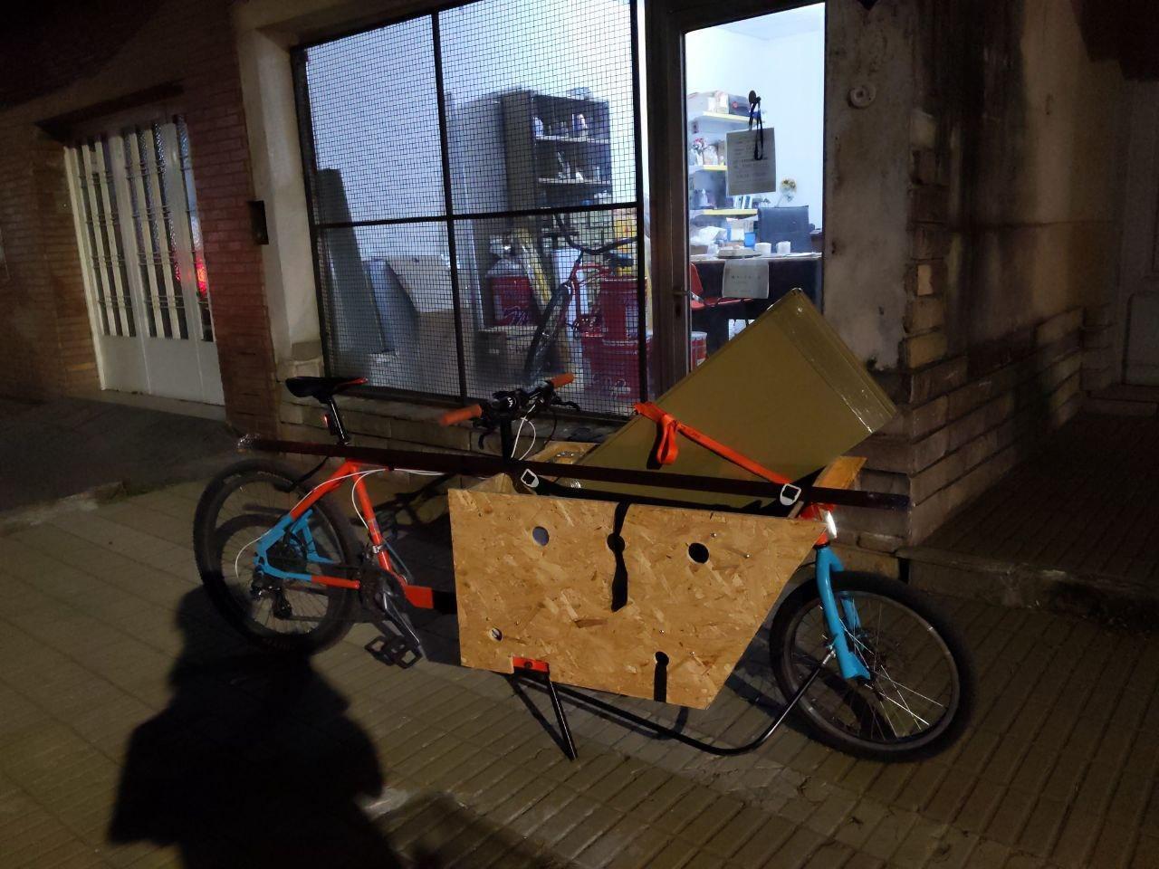 La bici de carga con una estantería y una caja de cerámica arriba